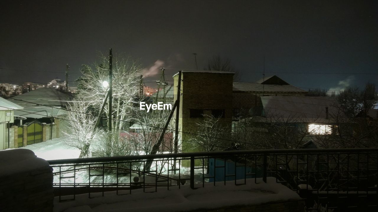 ILLUMINATED CITY AGAINST SKY DURING WINTER AT NIGHT