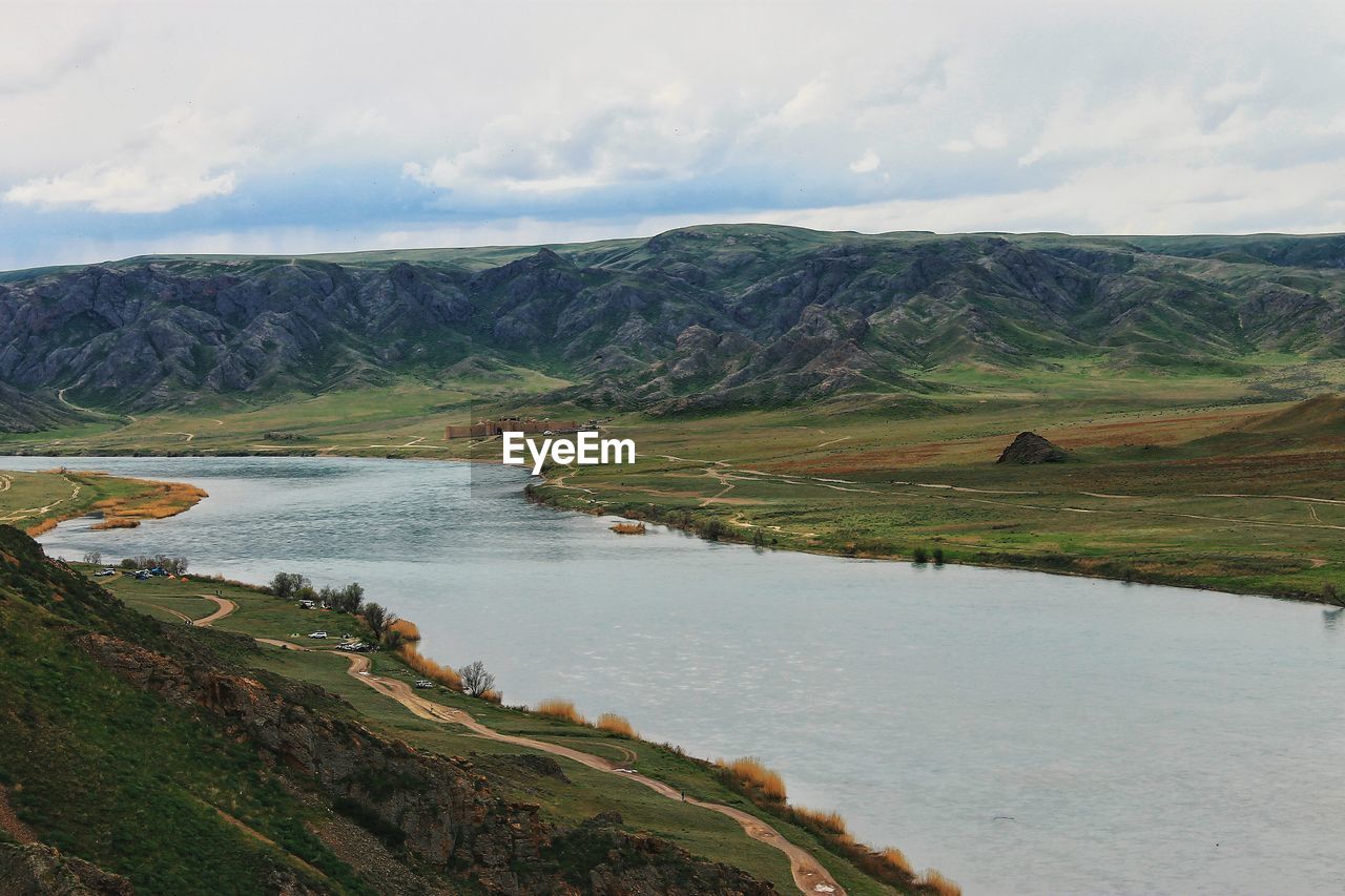 Scenic view of river by field against sky