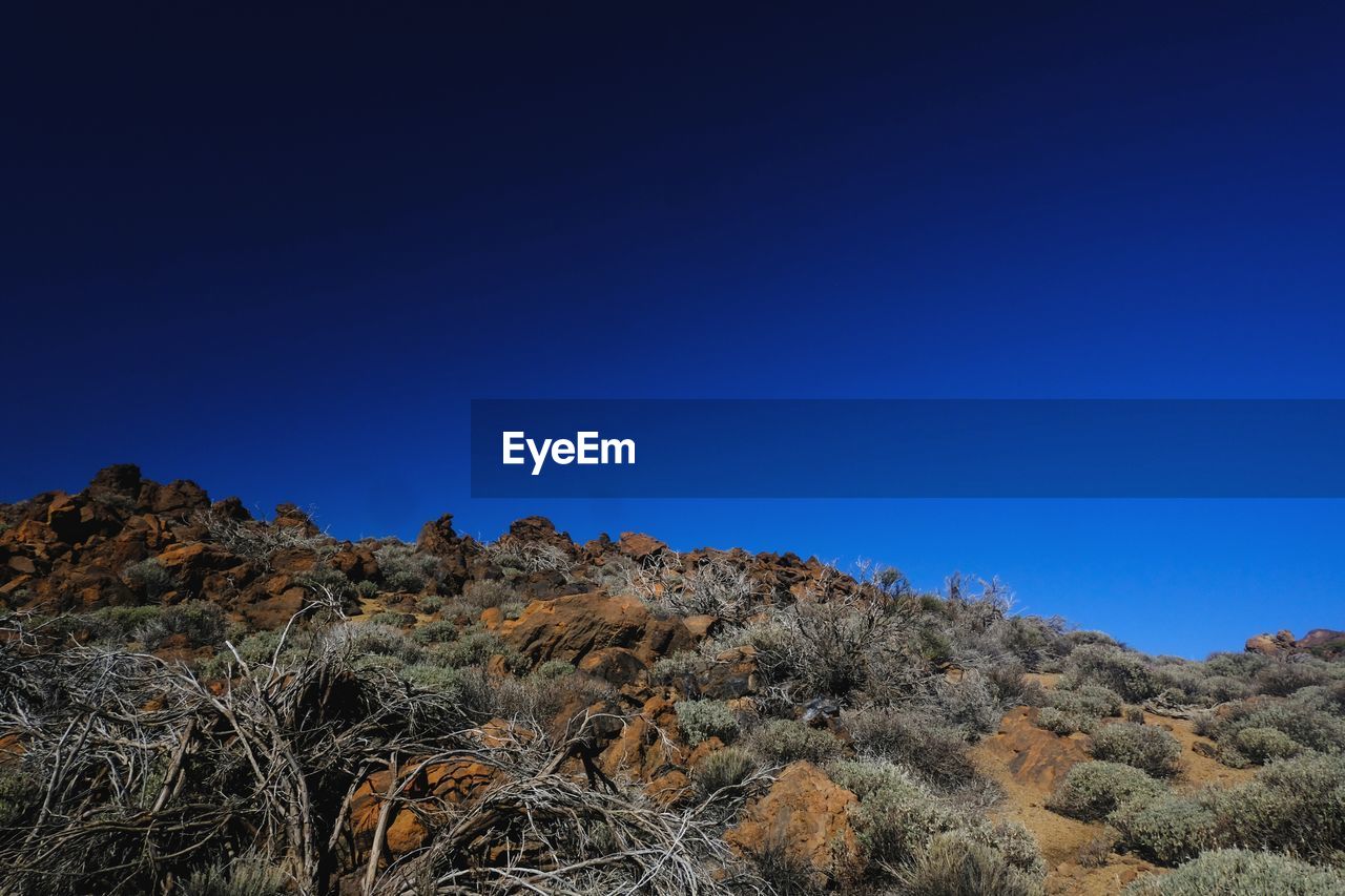 LOW ANGLE VIEW OF MOUNTAIN AGAINST BLUE SKY
