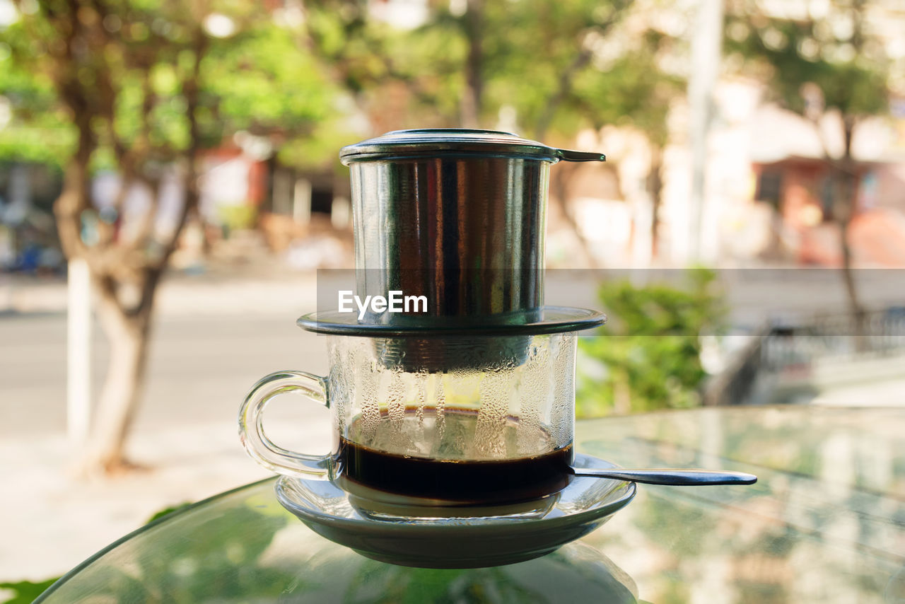 Drip black coffee in vietnamese style with condensed milk on a glass. method of making coffee.