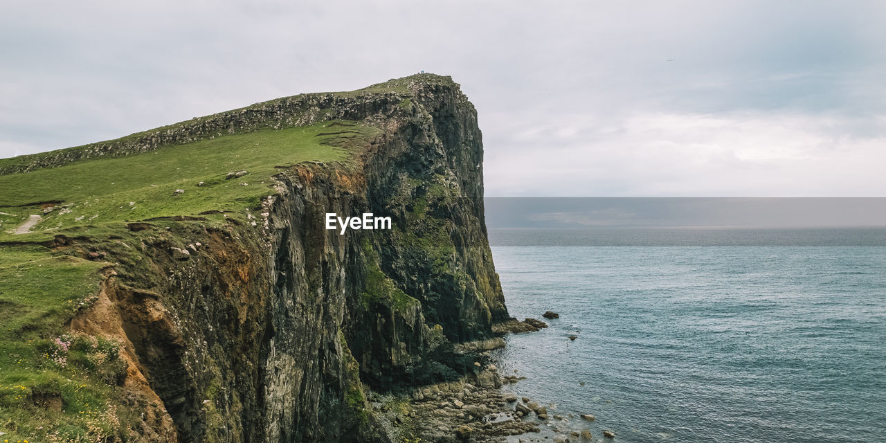Scenic view of old man of storr against cloudy sky