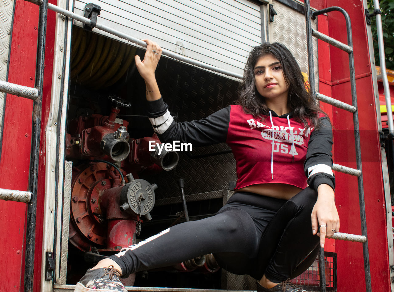 Portrait of young woman sitting on a truck outdoors