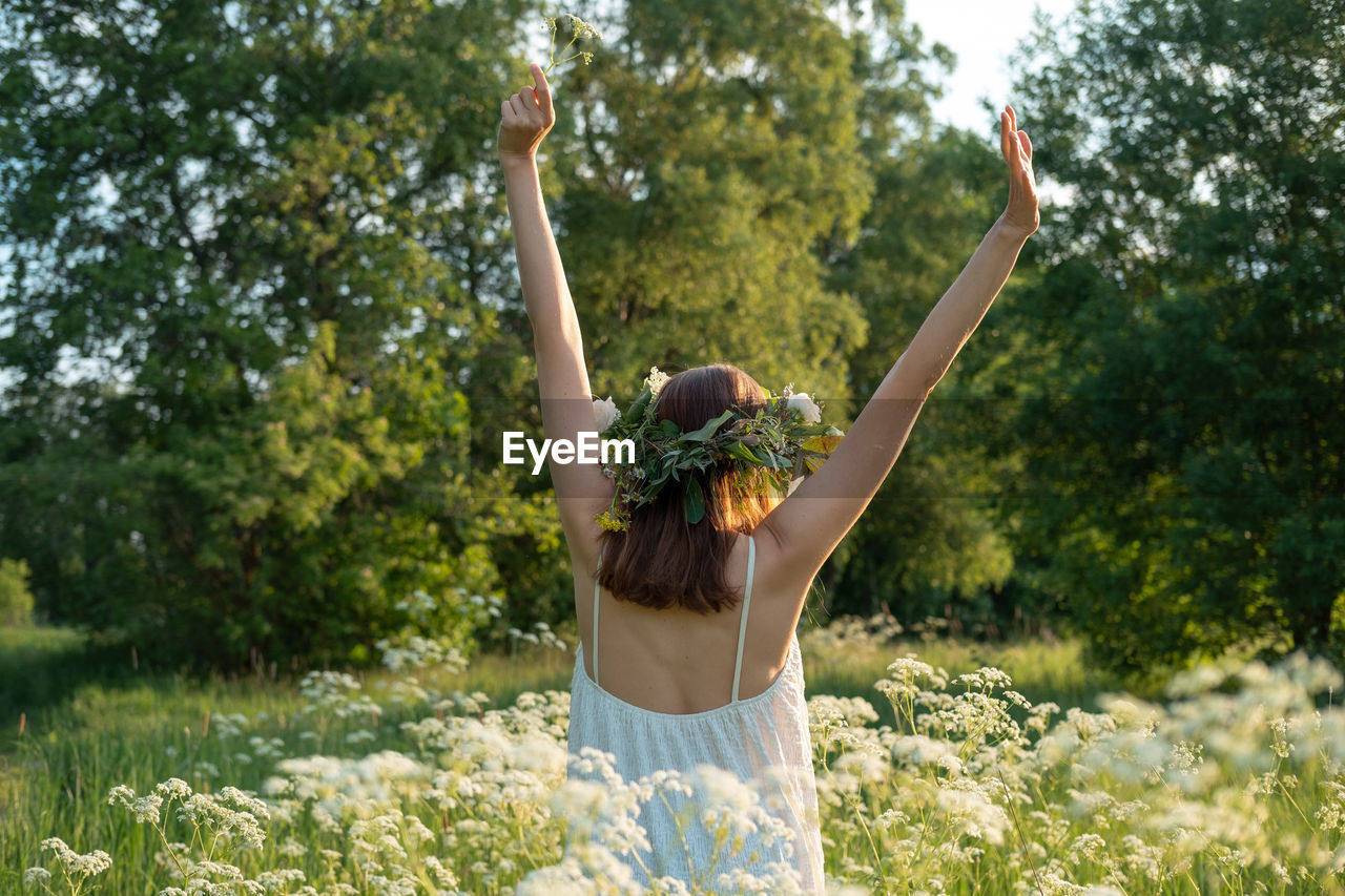 Rear view of woman wearing wreath amidst flowers