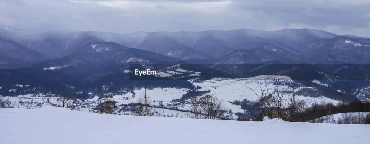 snow, winter, cold temperature, mountain, environment, scenics - nature, landscape, beauty in nature, mountain range, cloud, nature, sky, land, tree, forest, snowcapped mountain, travel destinations, plant, coniferous tree, pine tree, travel, tranquil scene, tranquility, pinaceae, no people, ridge, pine woodland, piste, non-urban scene, panoramic, outdoors, valley, tourism, holiday, winter sports, vacation, trip, woodland, sports, day, white