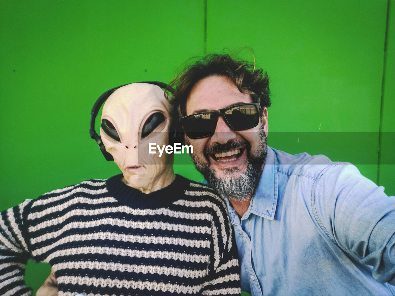 Portrait of smiling man with alien