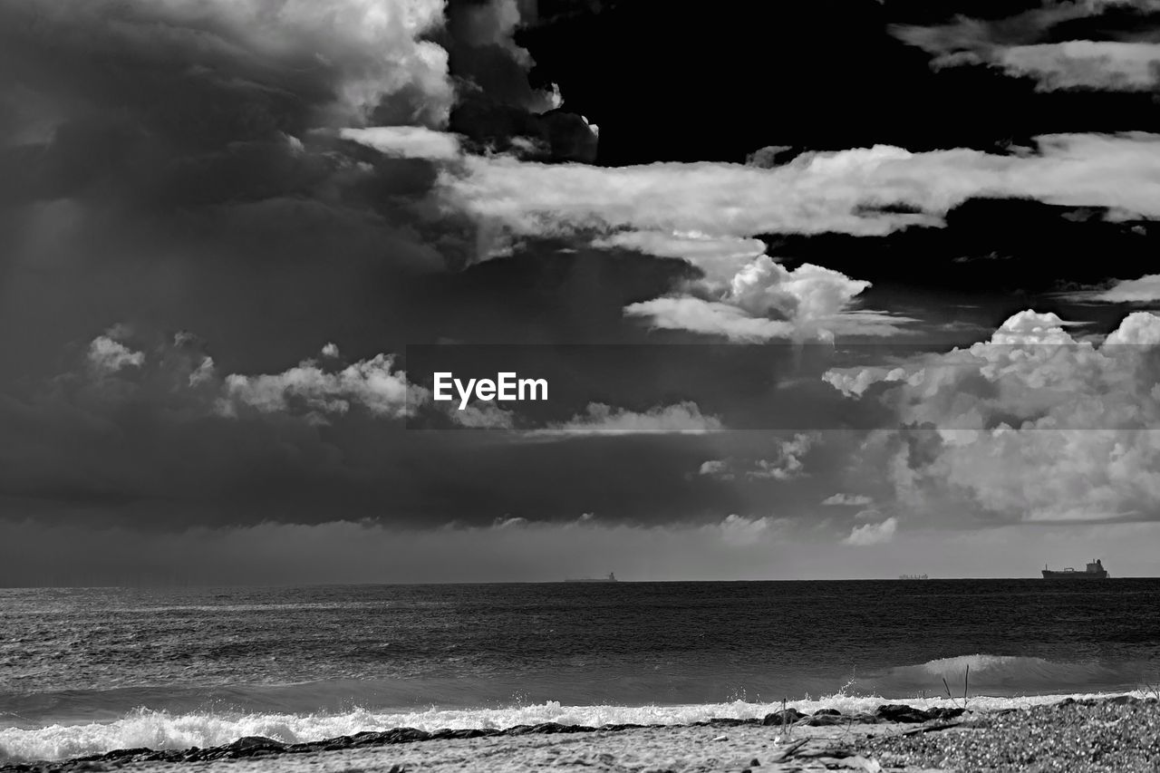 black and white, cloud, sky, sea, water, monochrome photography, monochrome, land, beach, beauty in nature, nature, environment, wave, scenics - nature, horizon, storm, ocean, storm cloud, wind wave, dramatic sky, horizon over water, cloudscape, coast, no people, outdoors, landscape, black, thunderstorm, white, motion, travel destinations, travel, darkness, tranquility, seascape