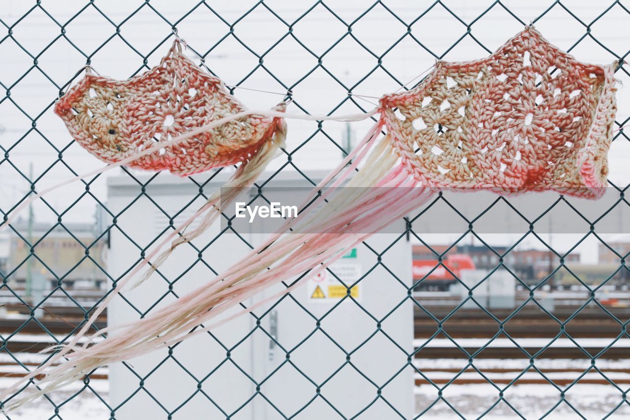 Close-up of decoration hanging on chainlink fence