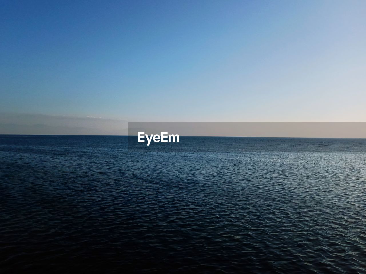 Scenic view of sea against clear sky at sunset