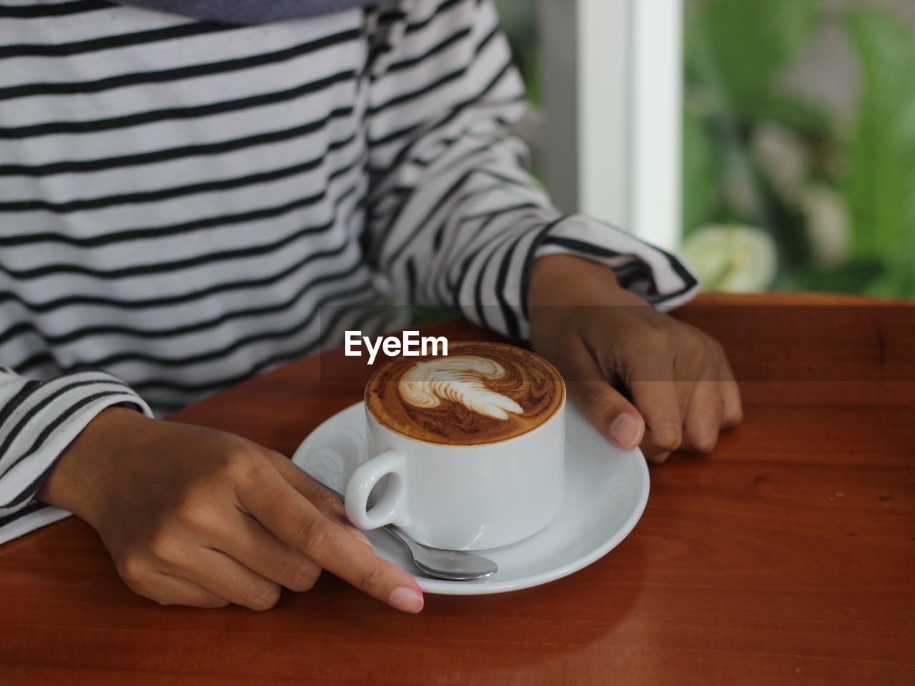 MIDSECTION OF MAN DRINKING COFFEE