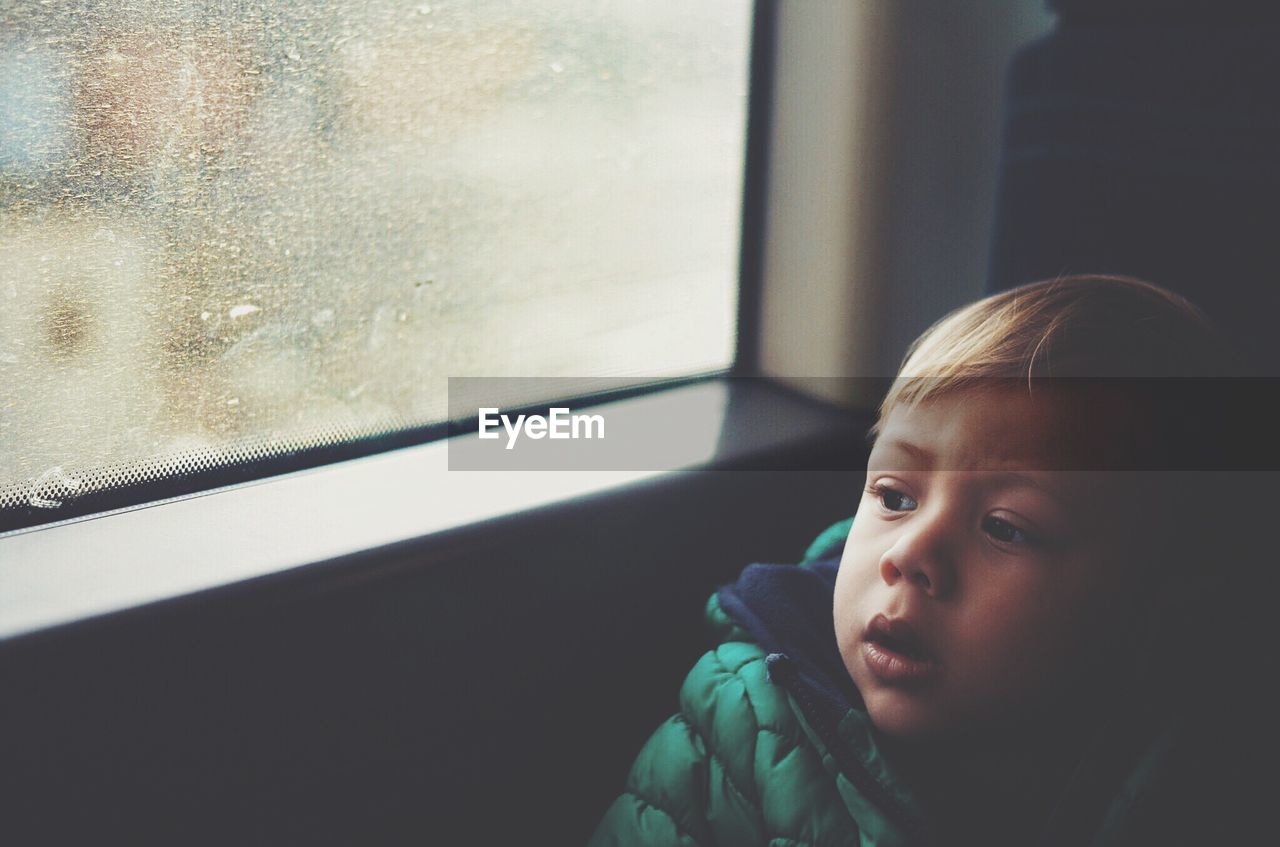 High angle view of boy looking through train window