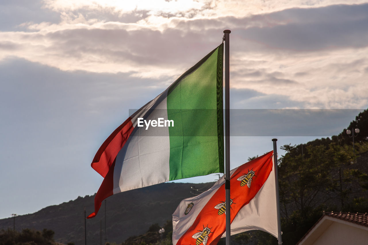 LOW ANGLE VIEW OF FLAG ON POLE AGAINST SKY