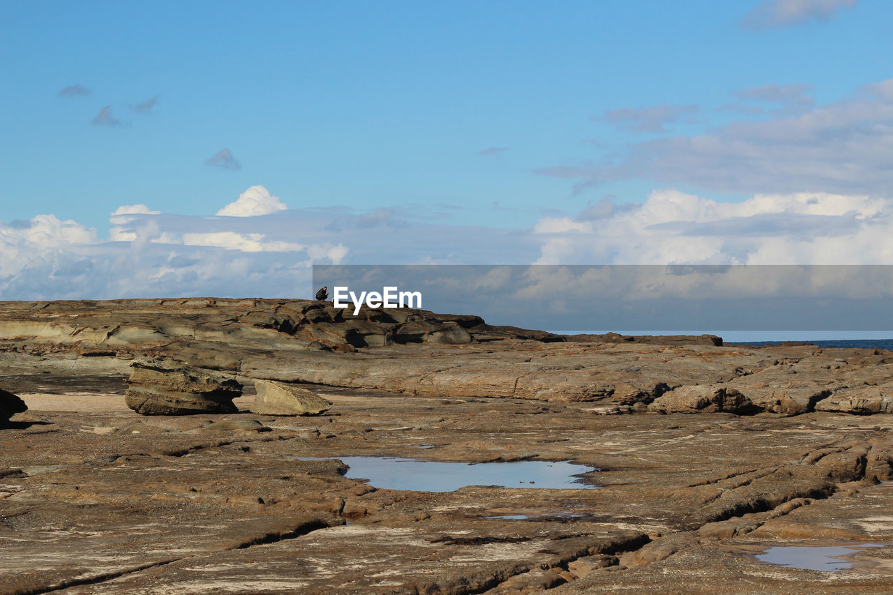 SCENIC VIEW OF ROCKS ON LAND AGAINST SKY