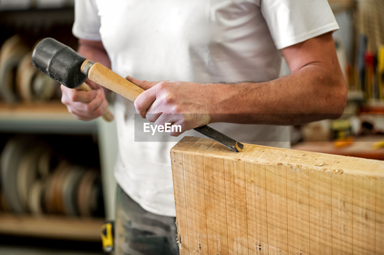 Midsection of carpenter working on table