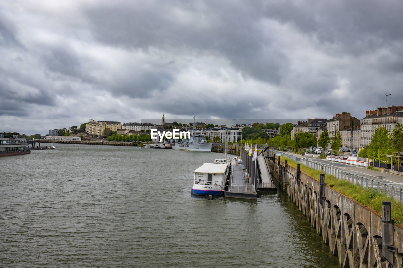 SCENIC VIEW OF RIVER AMIDST BUILDINGS AGAINST SKY