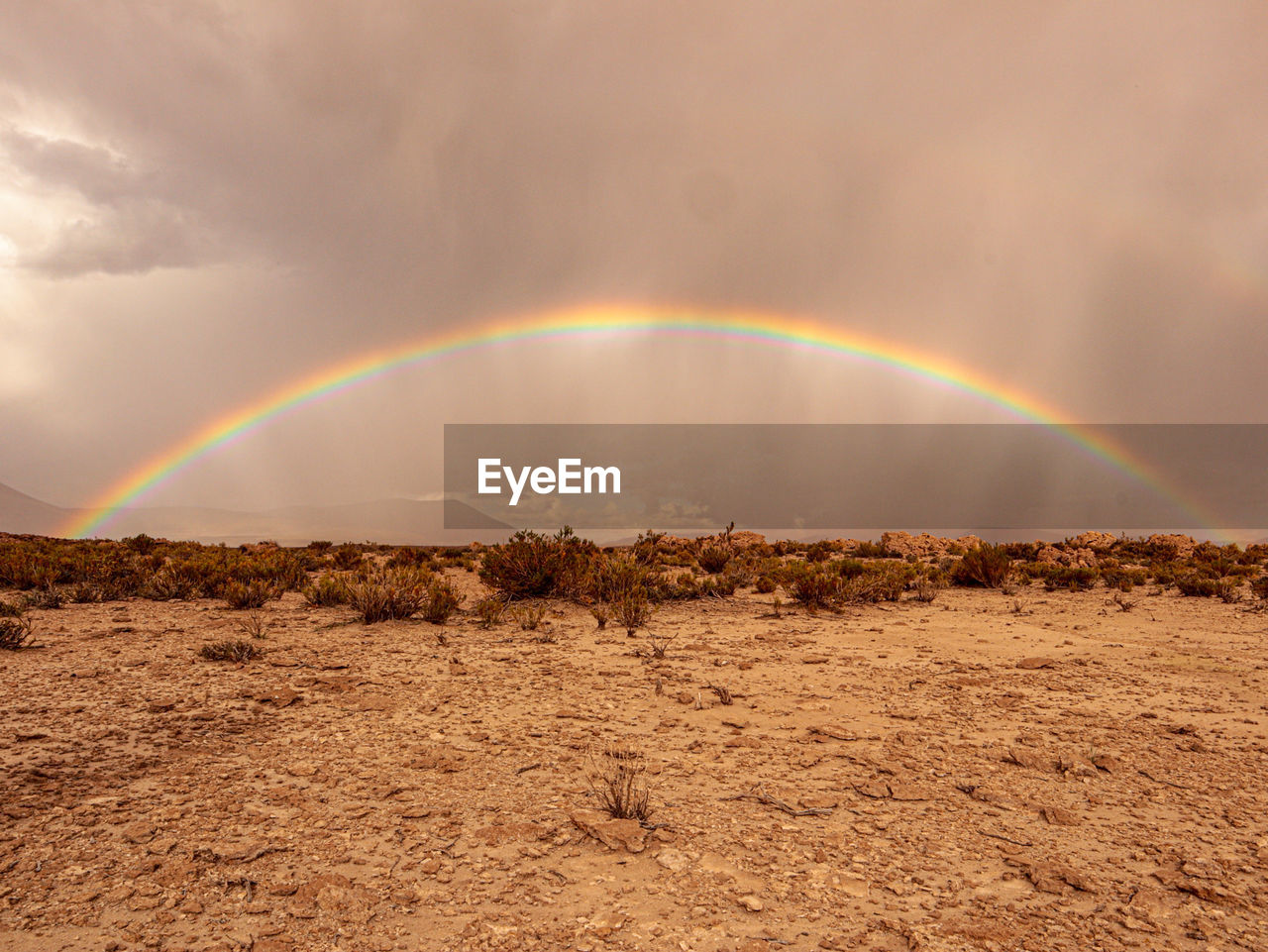 RAINBOW OVER LAND AGAINST SKY