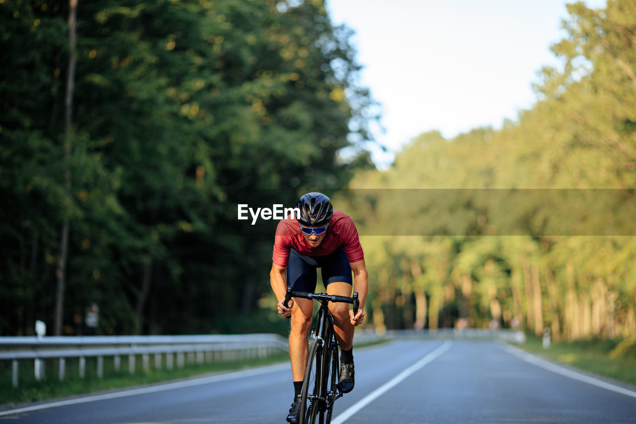 WOMAN RIDING BICYCLE ON ROAD