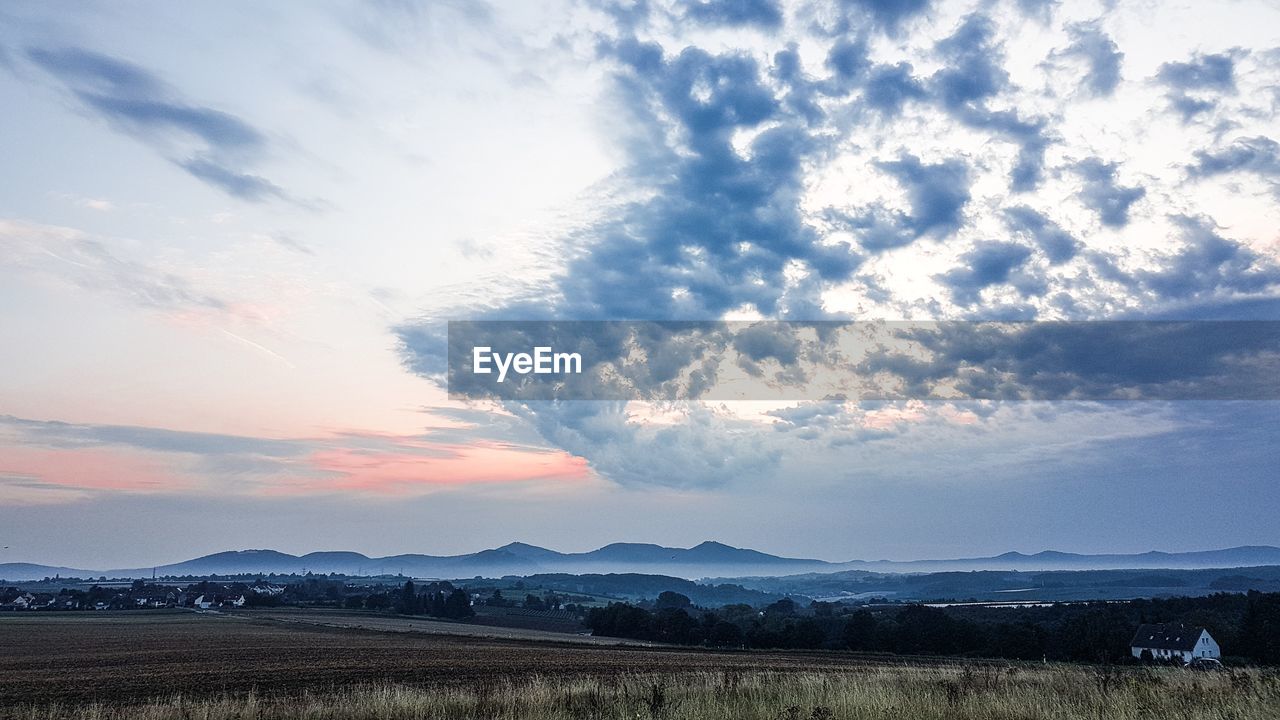 SCENIC VIEW OF FIELD AGAINST SKY AT SUNSET