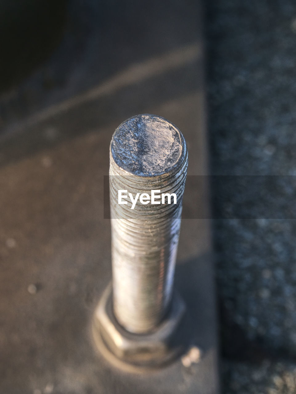Selective focus. detail of screw fixed metal plate to concrete base.
