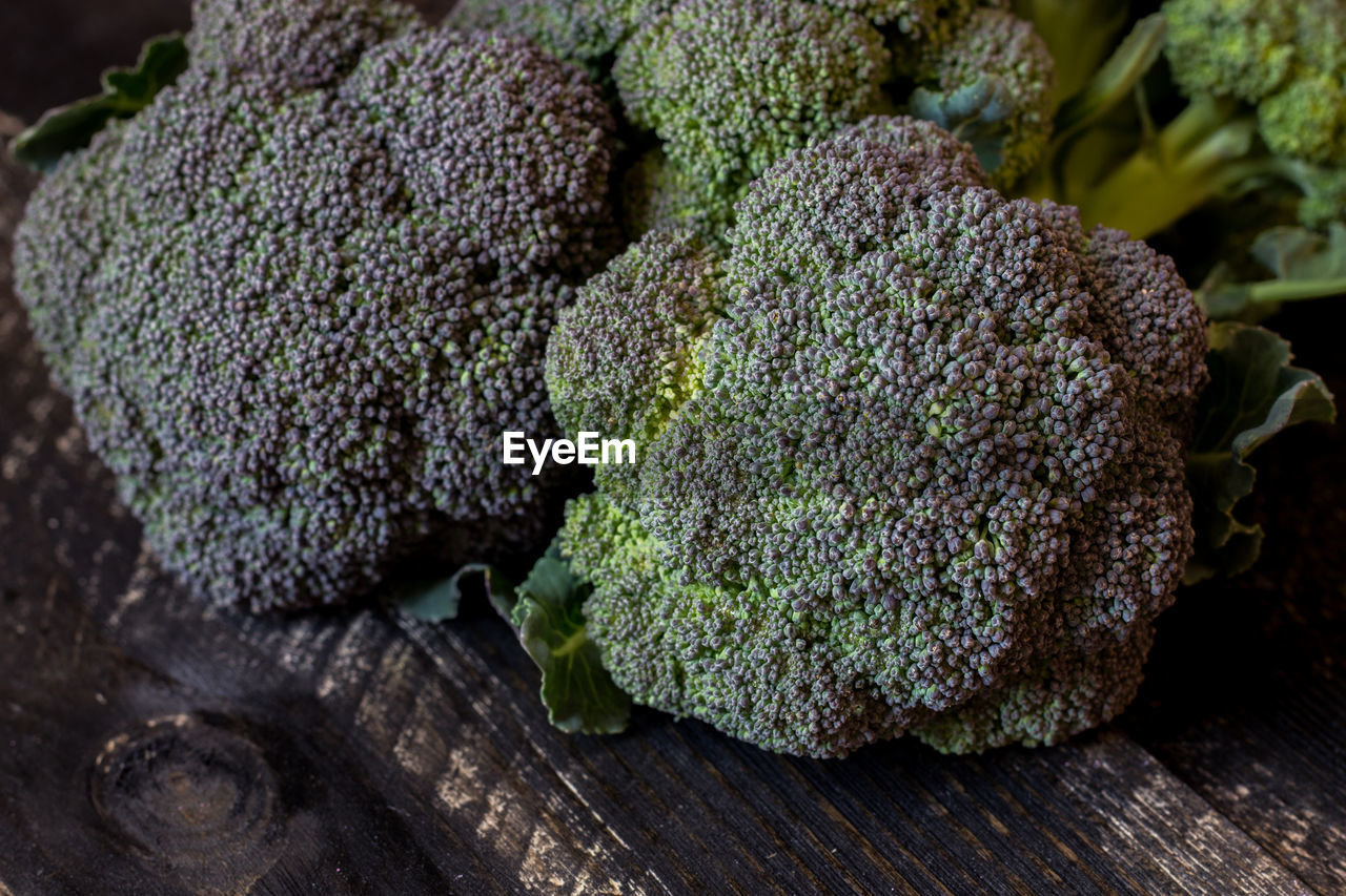 Freshly harvested organic barese broccoli, on black wooden background