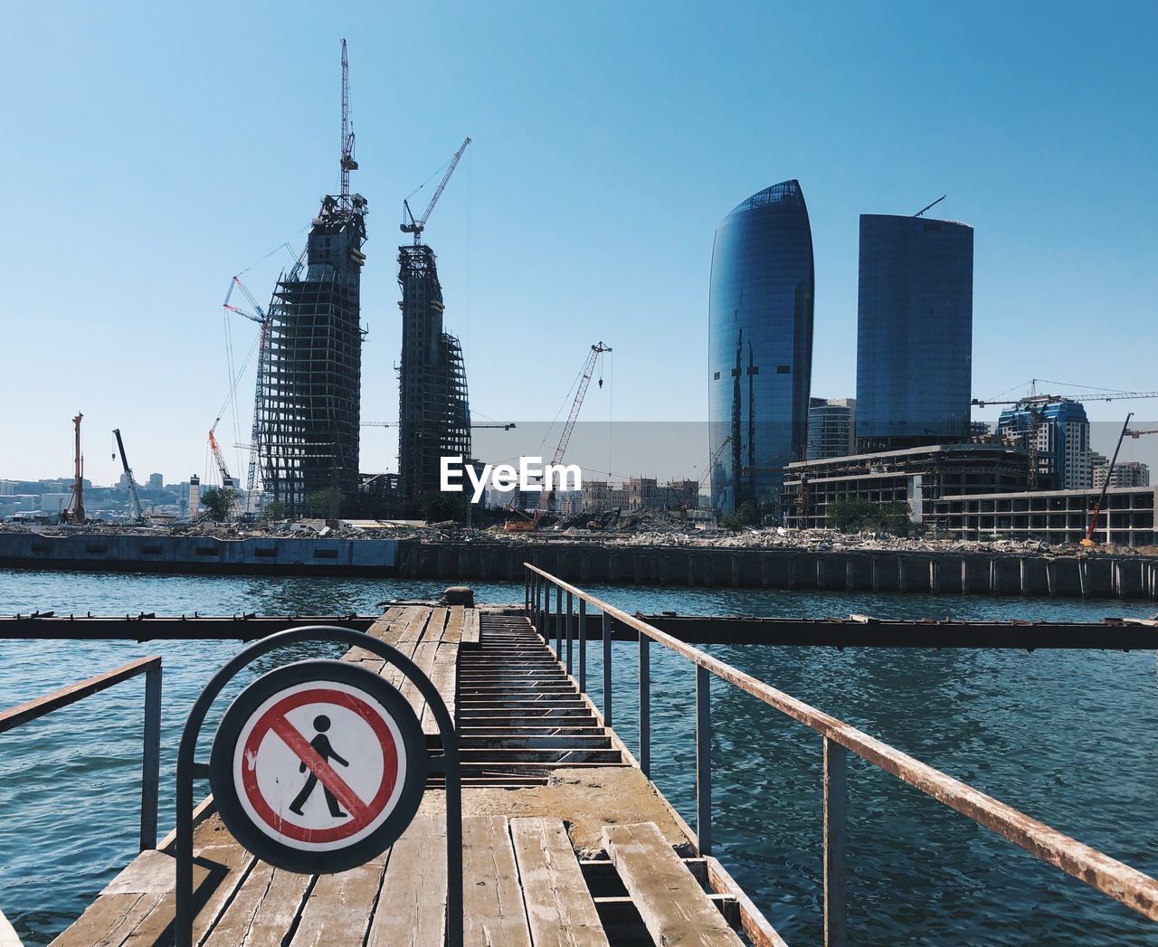 Modern buildings by river against sky in city