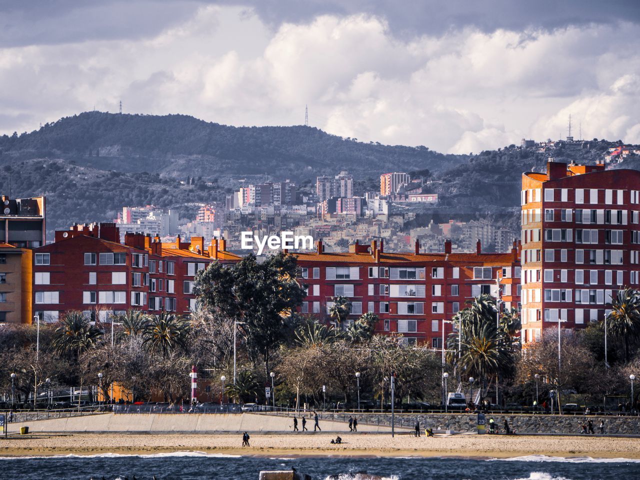 Buildings in city against cloudy sky