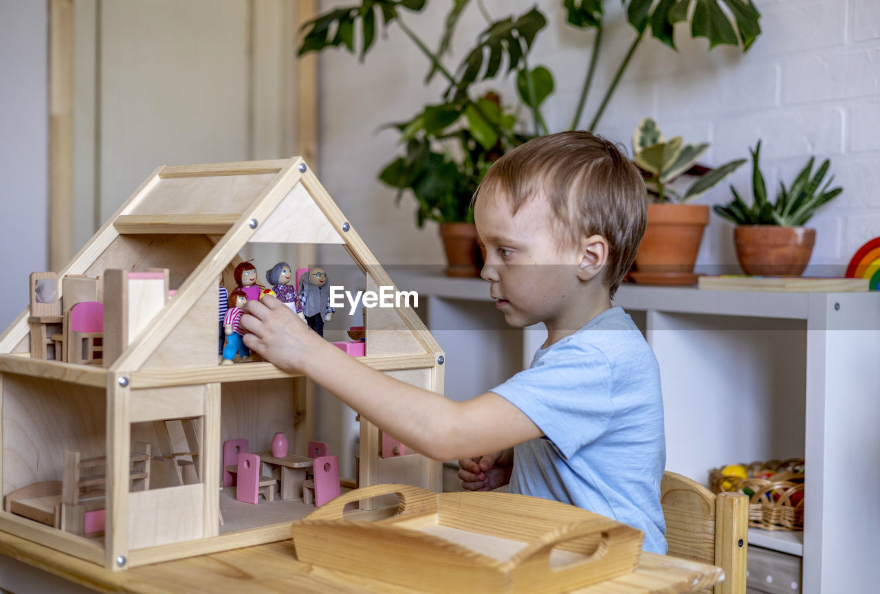 Boy playing with wooden toy at home