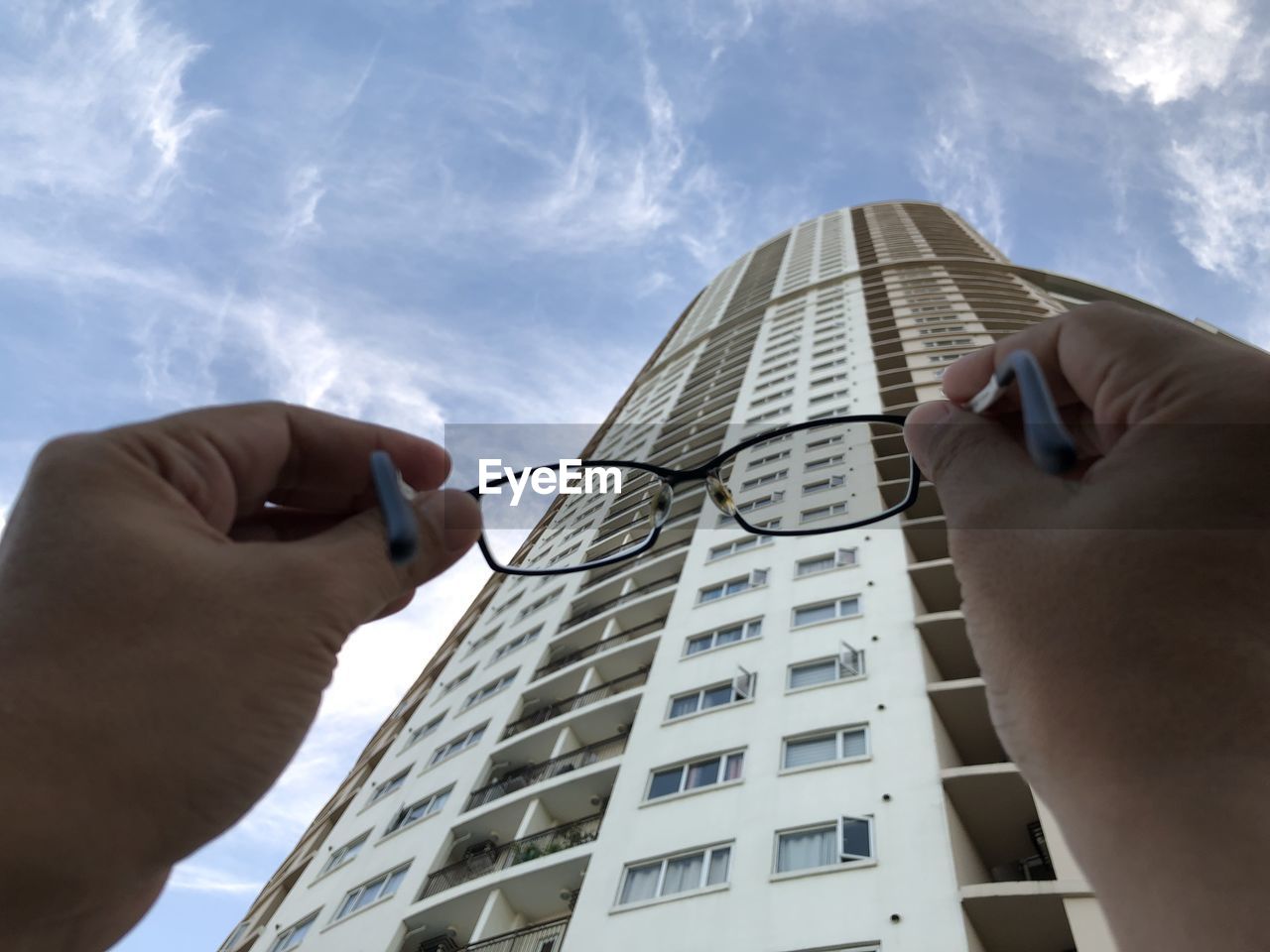 architecture, hand, building exterior, built structure, sky, city, skyscraper, low angle view, building, adult, cloud, office building exterior, one person, business, nature, blue, office, day, men, occupation, outdoors, finance, holding, working