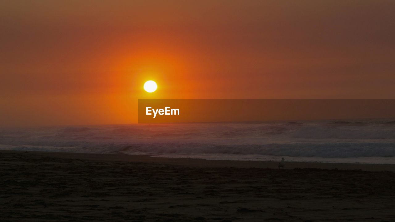 SCENIC VIEW OF SUNSET OVER SEA