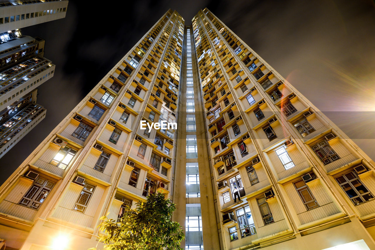 Low angle view of illuminated buildings at night in hong kong 