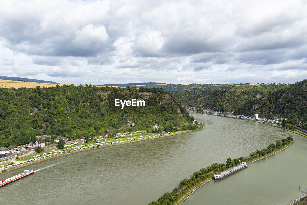 The river rhine in western germany flows between the hills covered with forest.