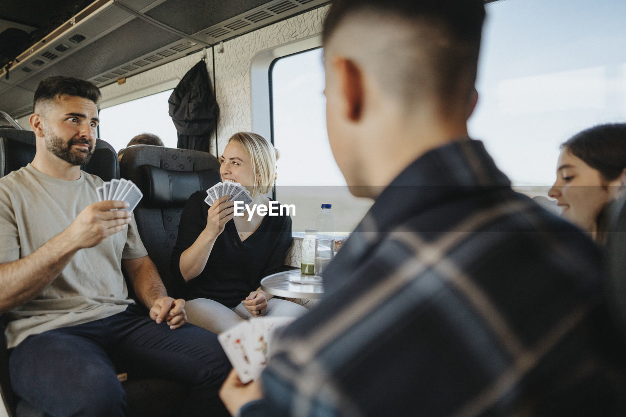 Family enjoying and having fun while playing cards in train