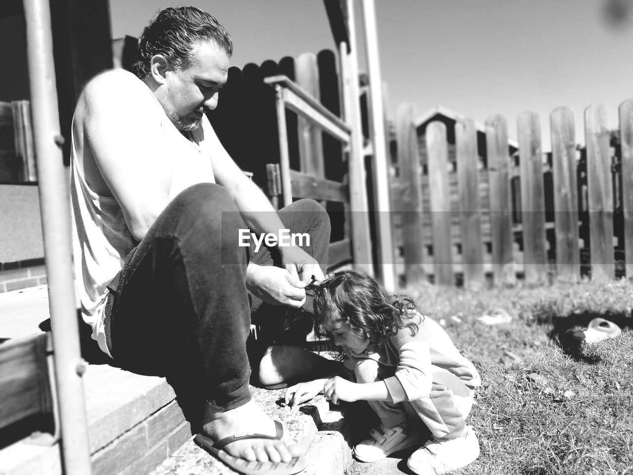 Full length of father with daughter sitting outdoors