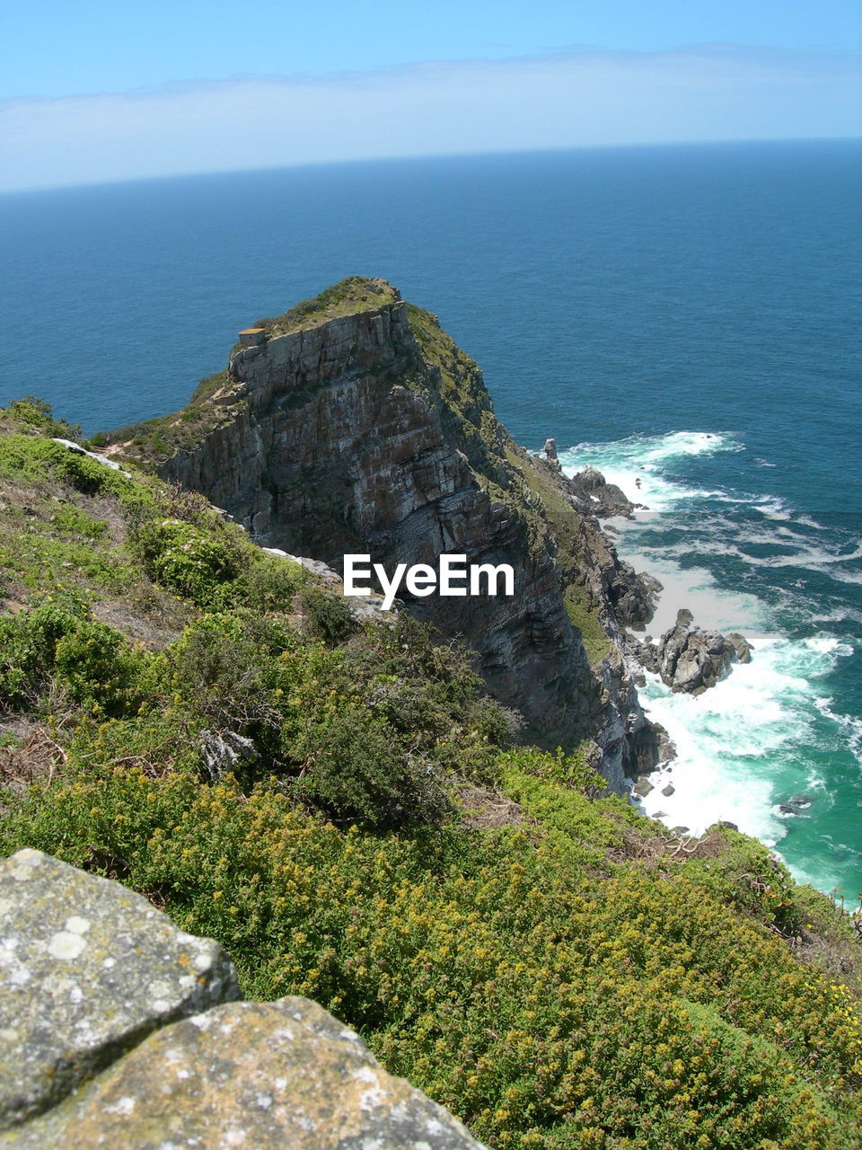 Scenic view of mountain at sea shore against sky