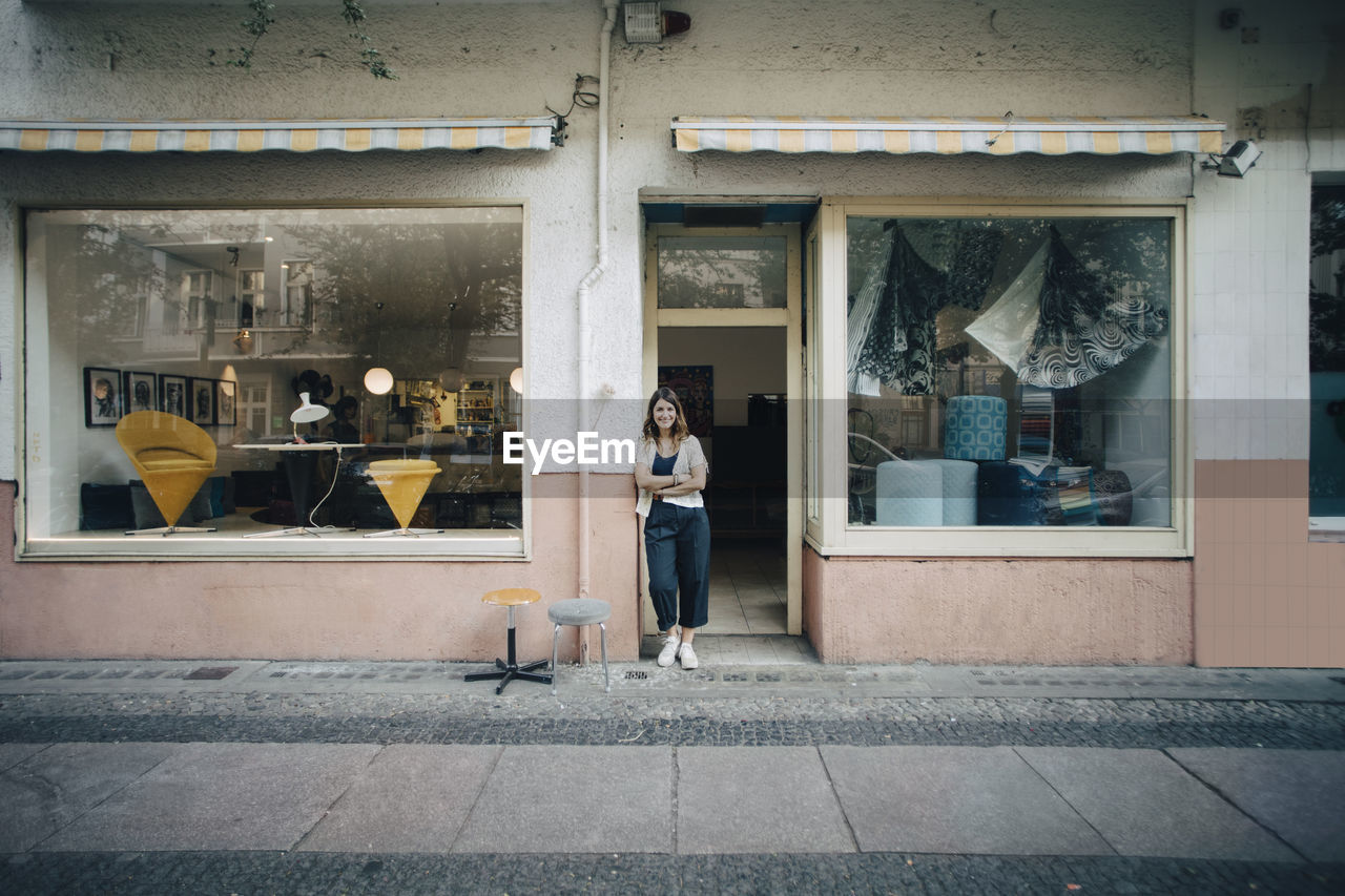 Portrait of confident female upholstery worker standing at workshop entrance