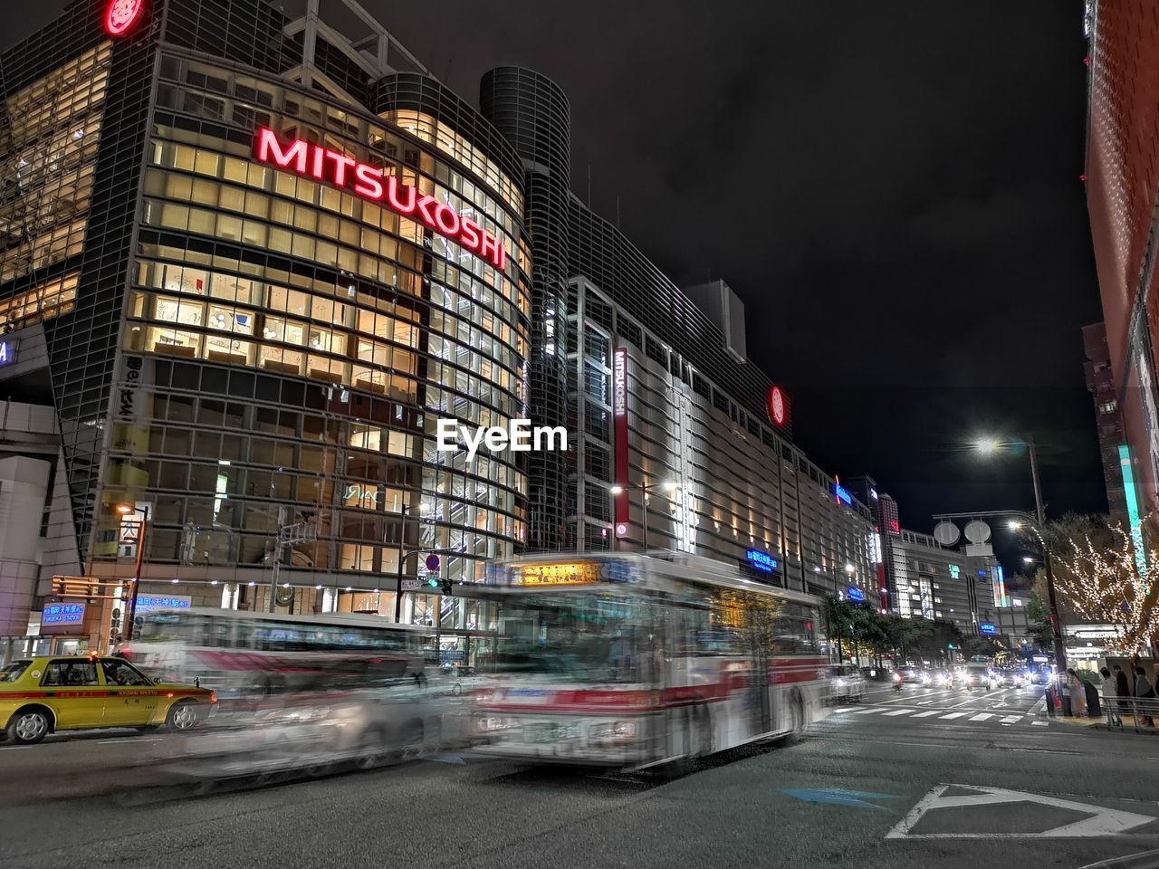 VIEW OF CITY STREET AND ILLUMINATED BUILDINGS AT NIGHT