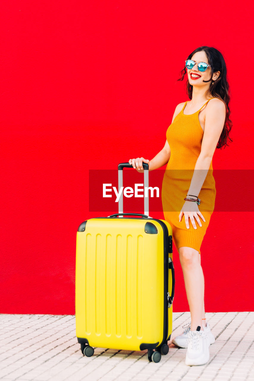 WOMAN WEARING SUNGLASSES STANDING AGAINST RED FIRE