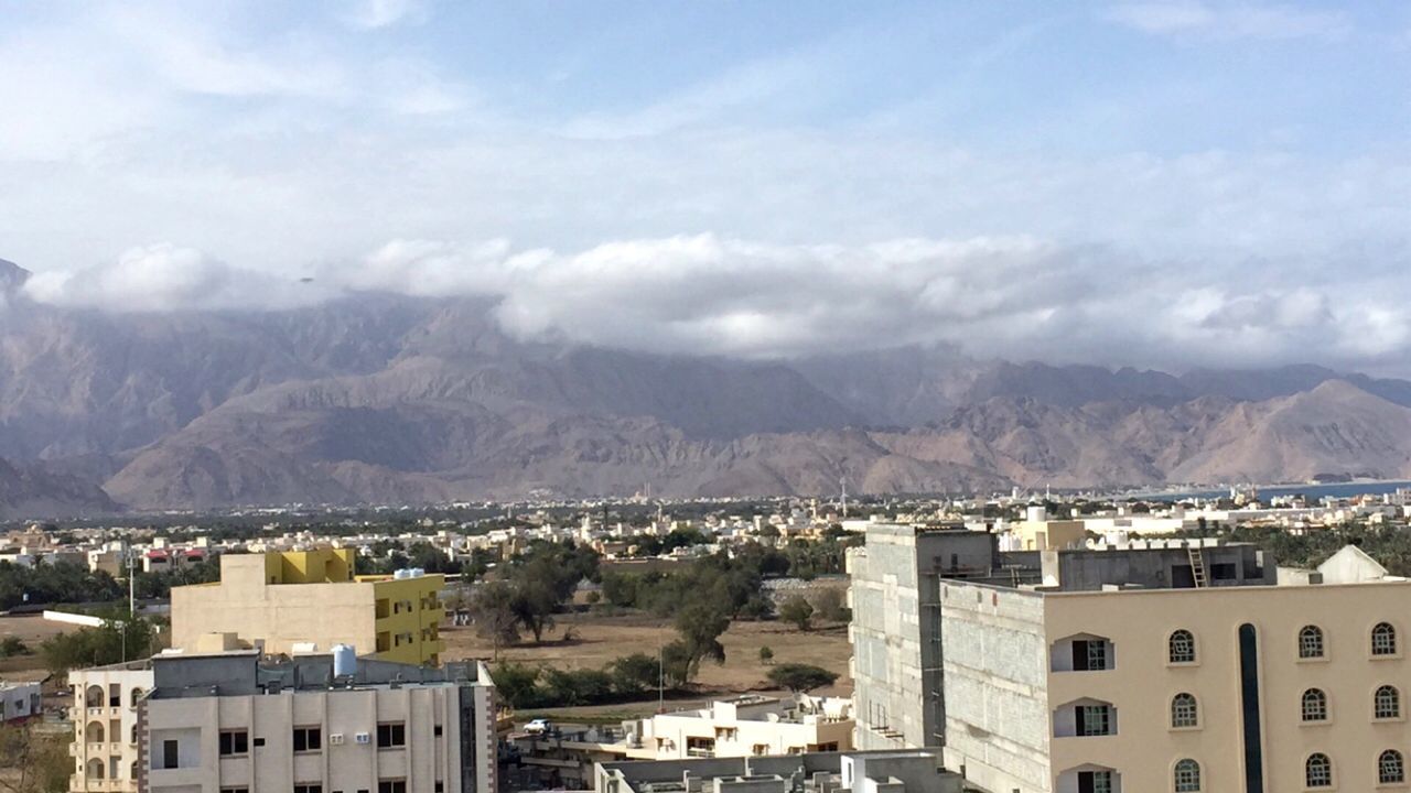 View of cityscape against cloudy sky