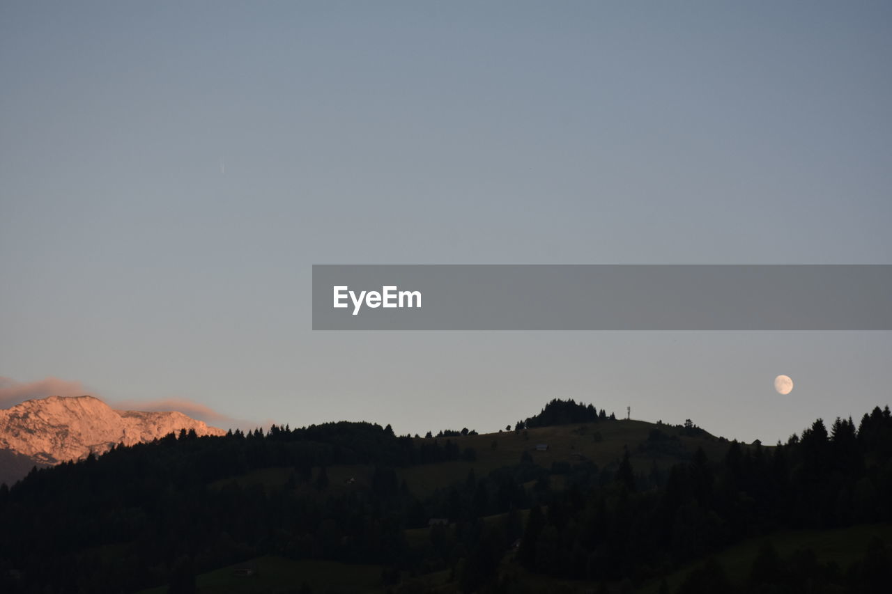 SCENIC VIEW OF MOUNTAINS AGAINST CLEAR SKY AT SUNSET