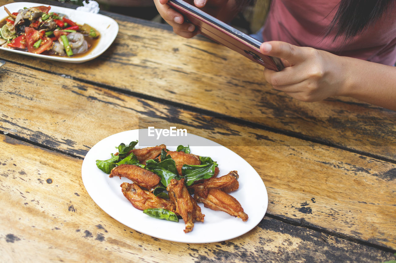 High angle view of fried chicken wing tips in plate on table