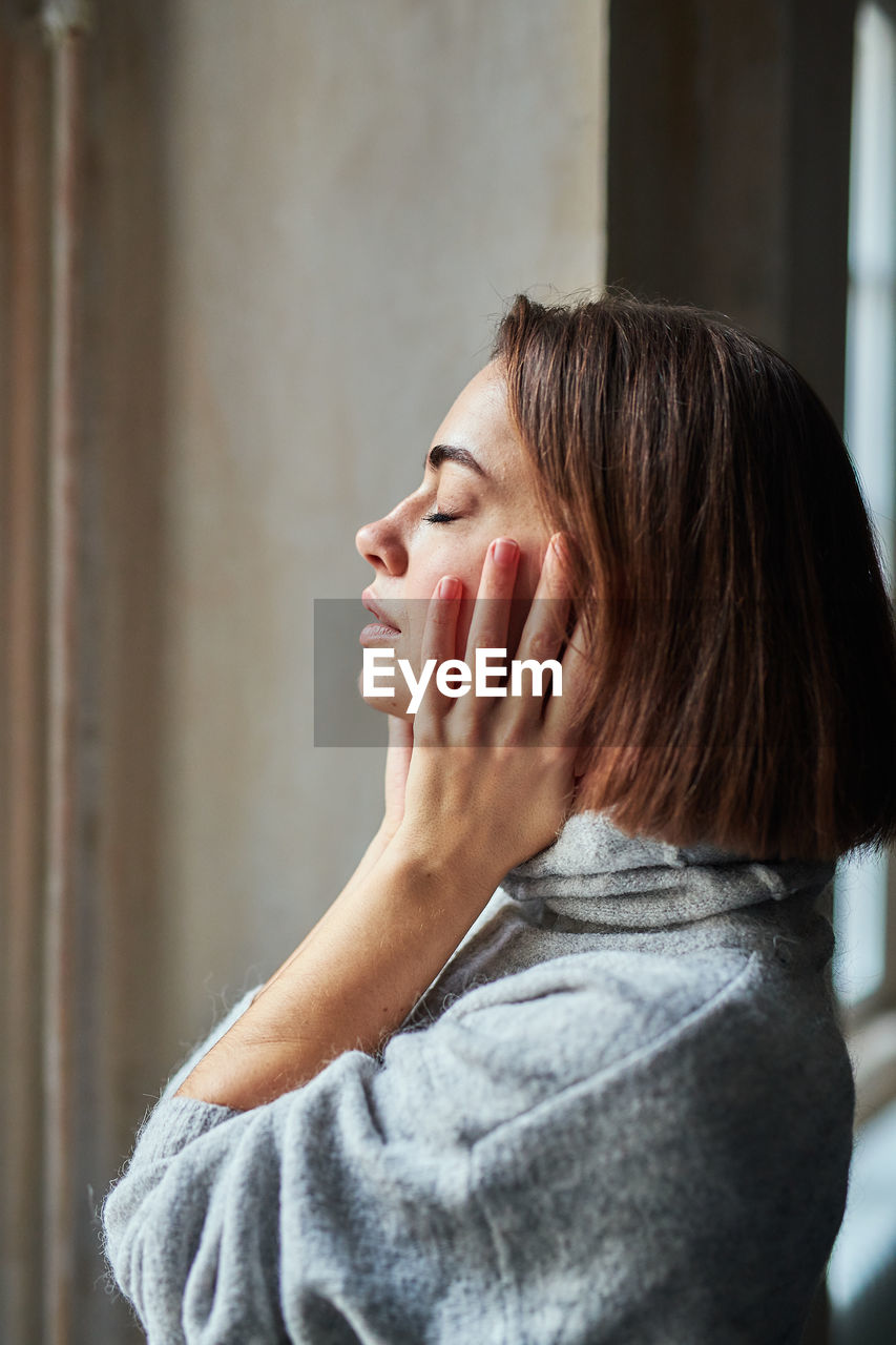 Woman with closed eyes at home