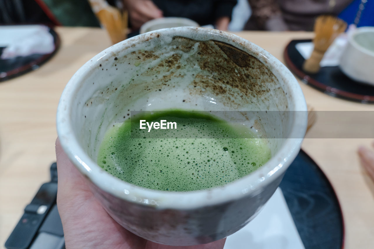 CLOSE-UP OF PERSON HAND HOLDING DRINK