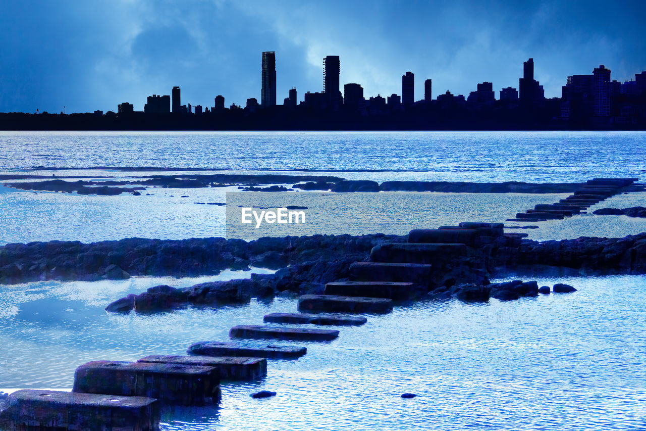 Scenic view of sea by buildings against sky