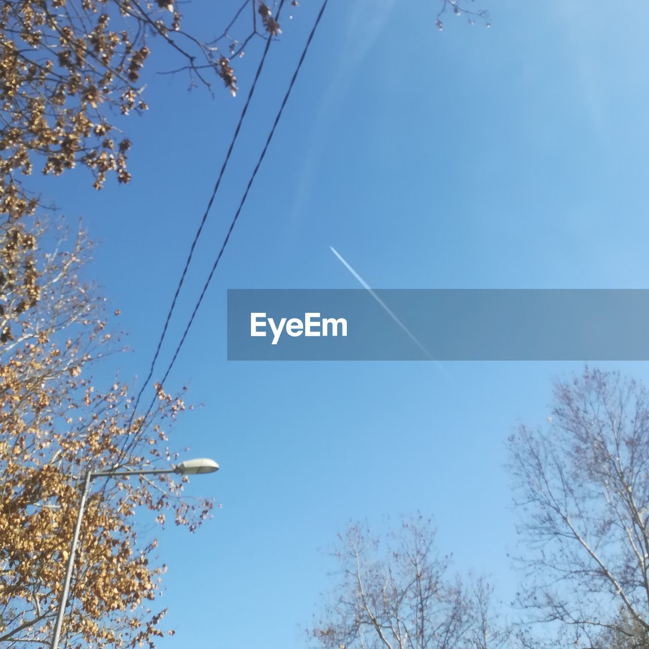 LOW ANGLE VIEW OF VAPOR TRAIL AGAINST BLUE SKY