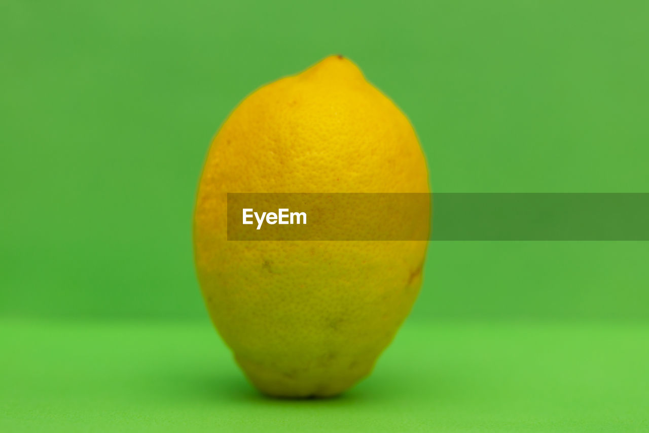 citrus, healthy eating, fruit, food, food and drink, plant, studio shot, wellbeing, produce, freshness, colored background, yellow, green, single object, no people, indoors, citrus fruit, lemon, close-up, green background, macro photography, ripe, copy space