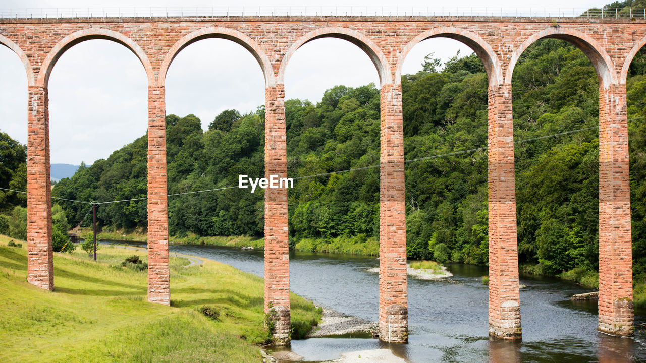 ARCH BRIDGE OVER RIVER IN PARK