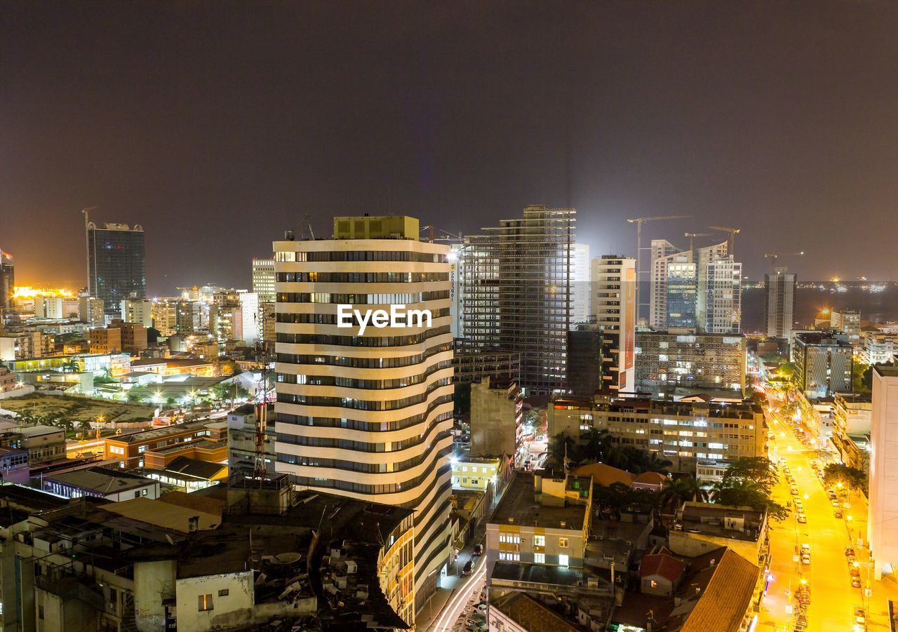 Illuminated cityscape against sky at night