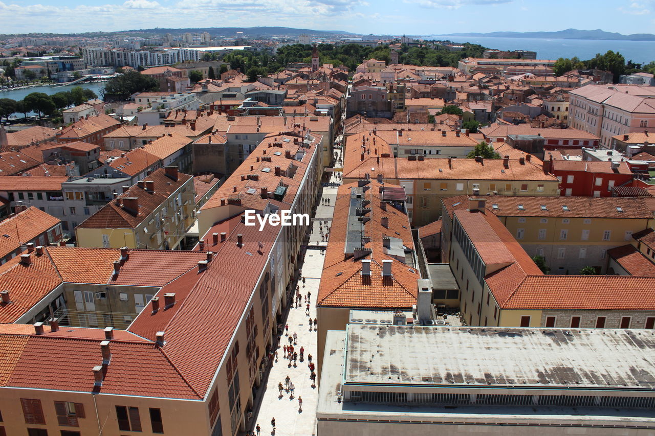 Aerial view of houses in town against sky