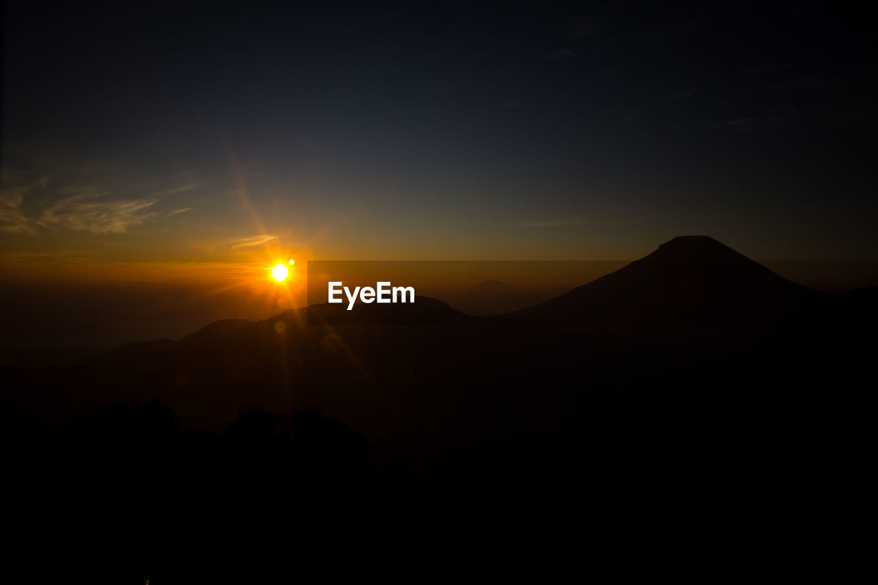 Silhouette mountains against sky at sunrise