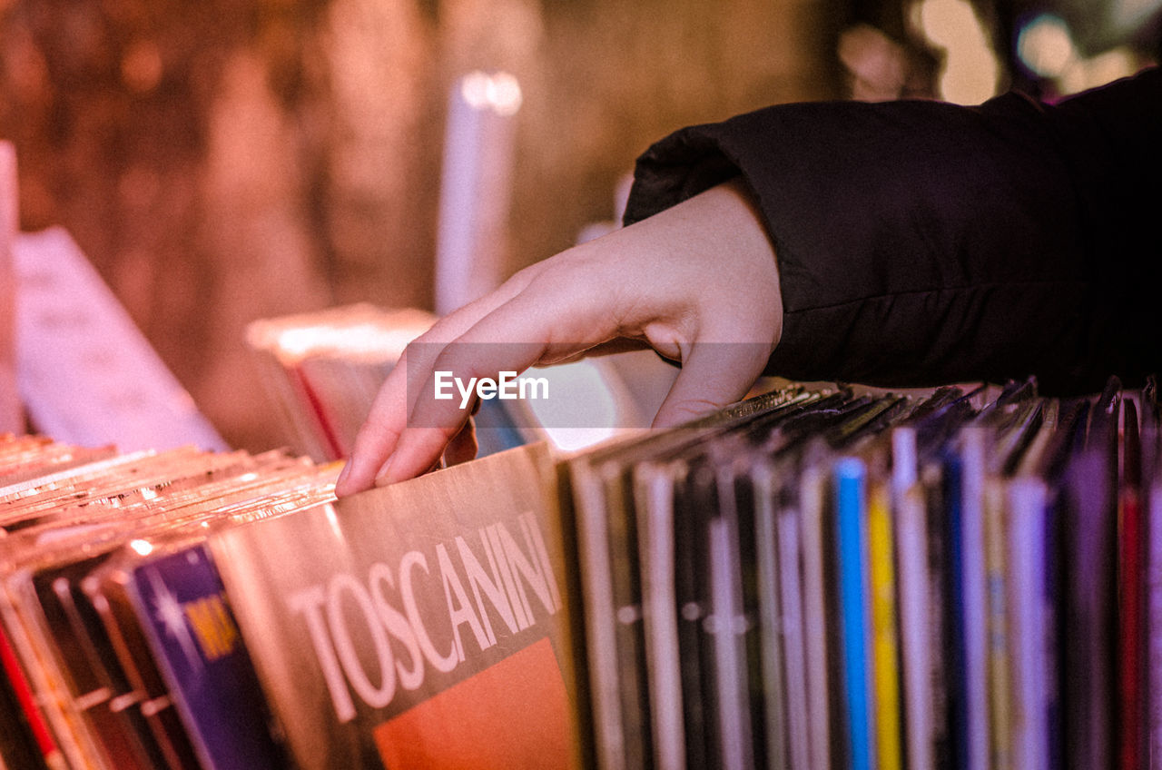 Cropped hand choosing vinyl in shop