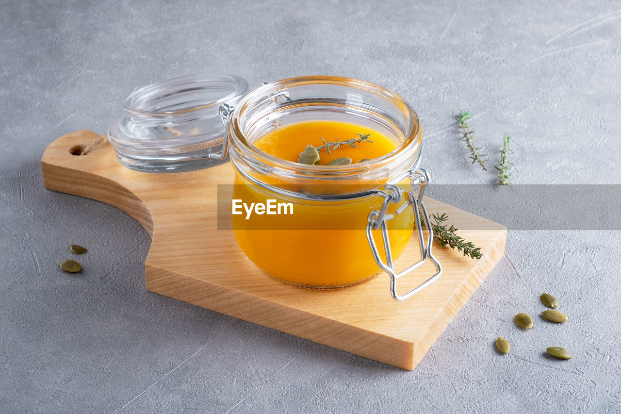 food and drink, food, healthy eating, jar, wellbeing, studio shot, freshness, container, indoors, fruit, spice, no people, wood, ingredient, herb, still life, high angle view, gray, yellow, household equipment, drink, produce, glass, gray background, plant, honey, citrus fruit, refreshment, kitchen utensil